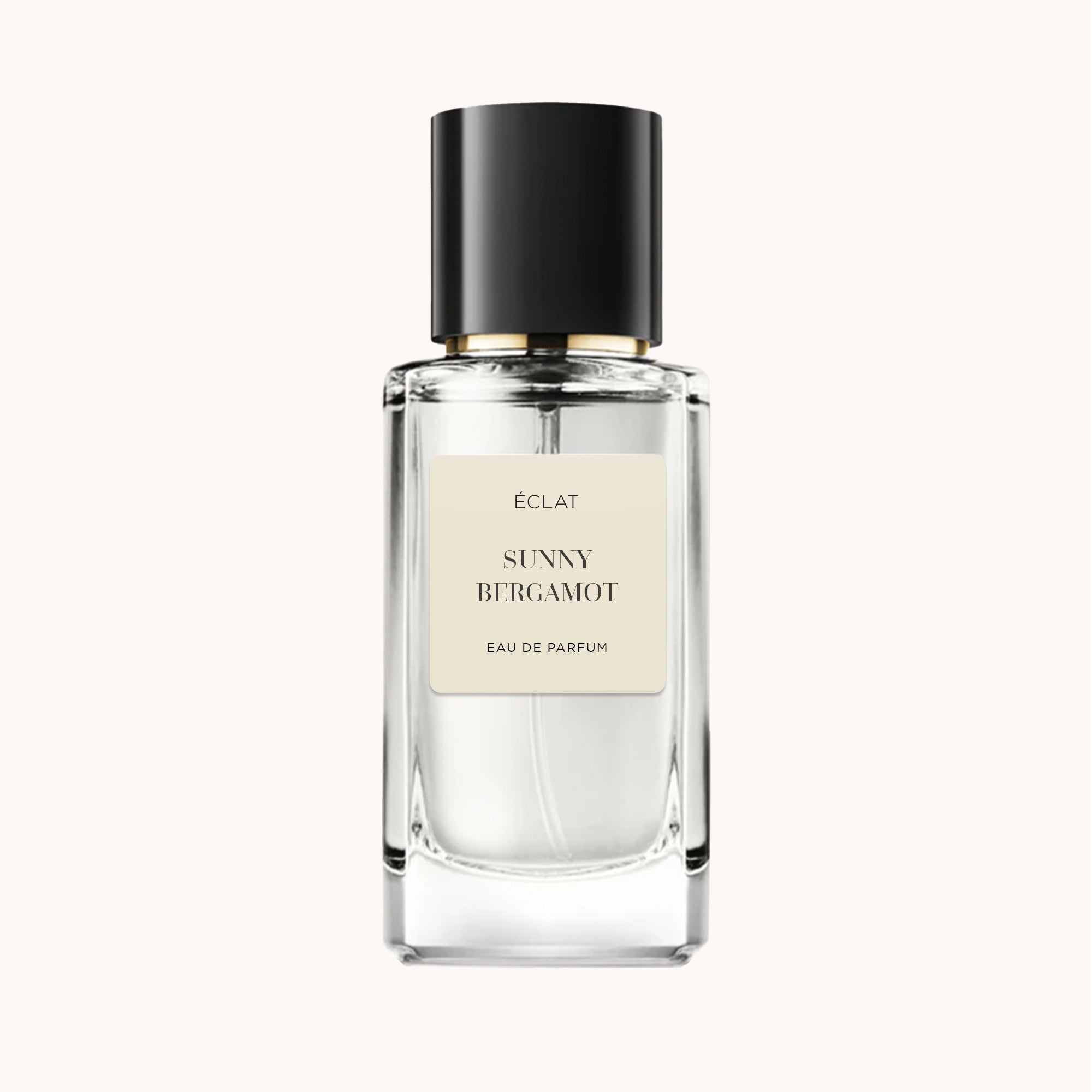 Faceted glass bottle of ÉCLAT Sunny Bergamot with a black cap and a cream label.