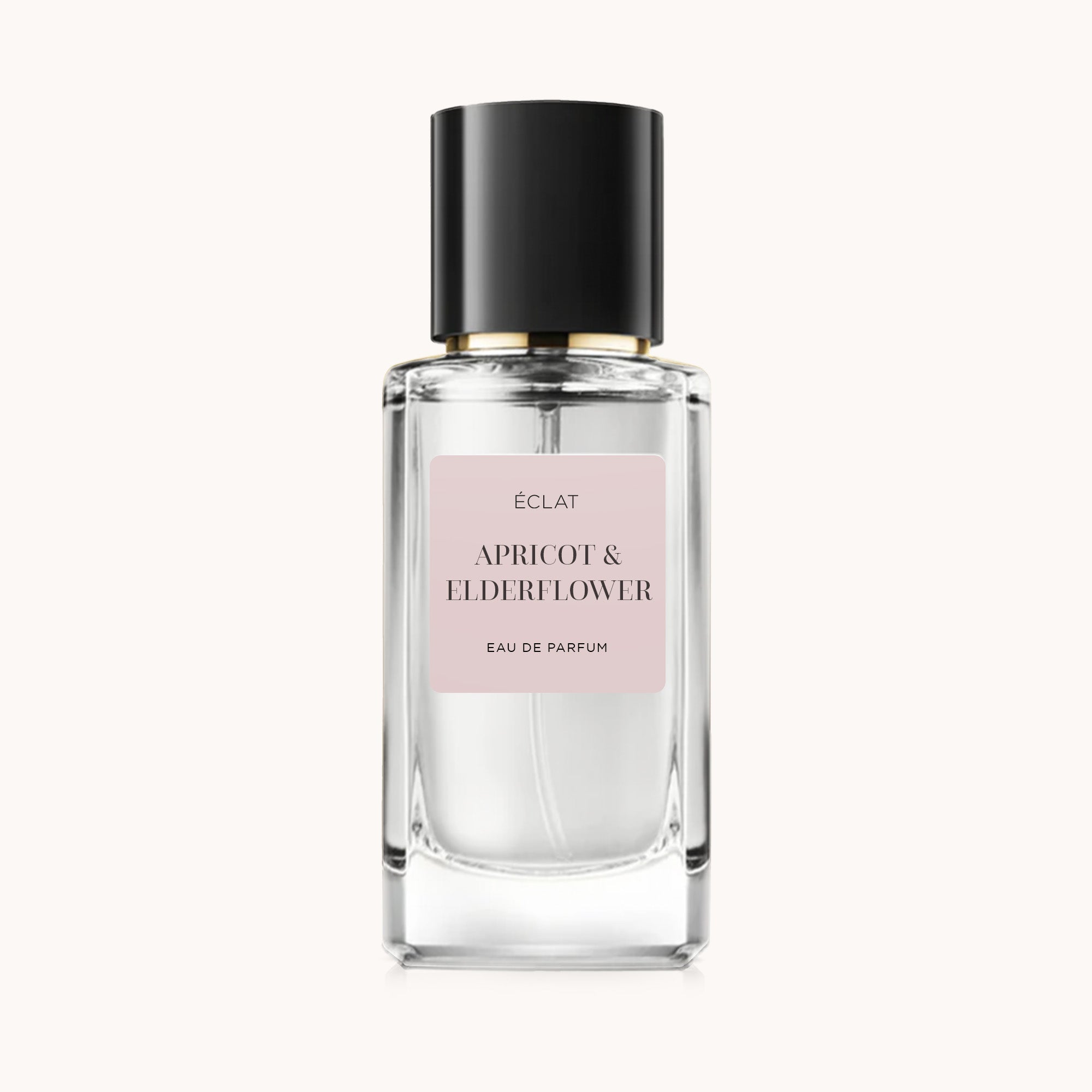 Um frasco de vidro facetado de ÉCLAT Apricot & Elderflower com tampa preta e etiqueta rosa suave.