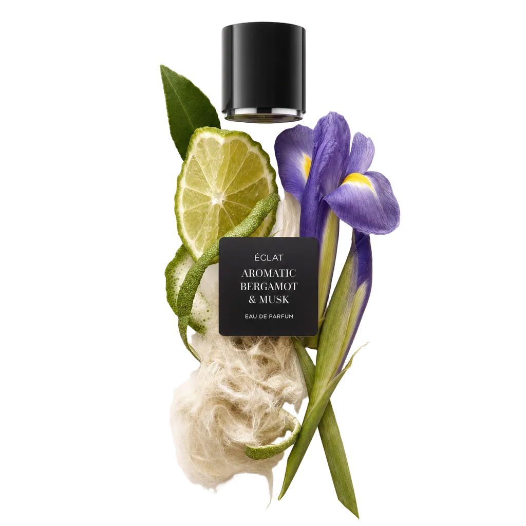 Um arranjo de ingredientes com bergamota fatiada, íris, texturas fibrosas e uma tampa preta ÉCLAT com etiqueta.