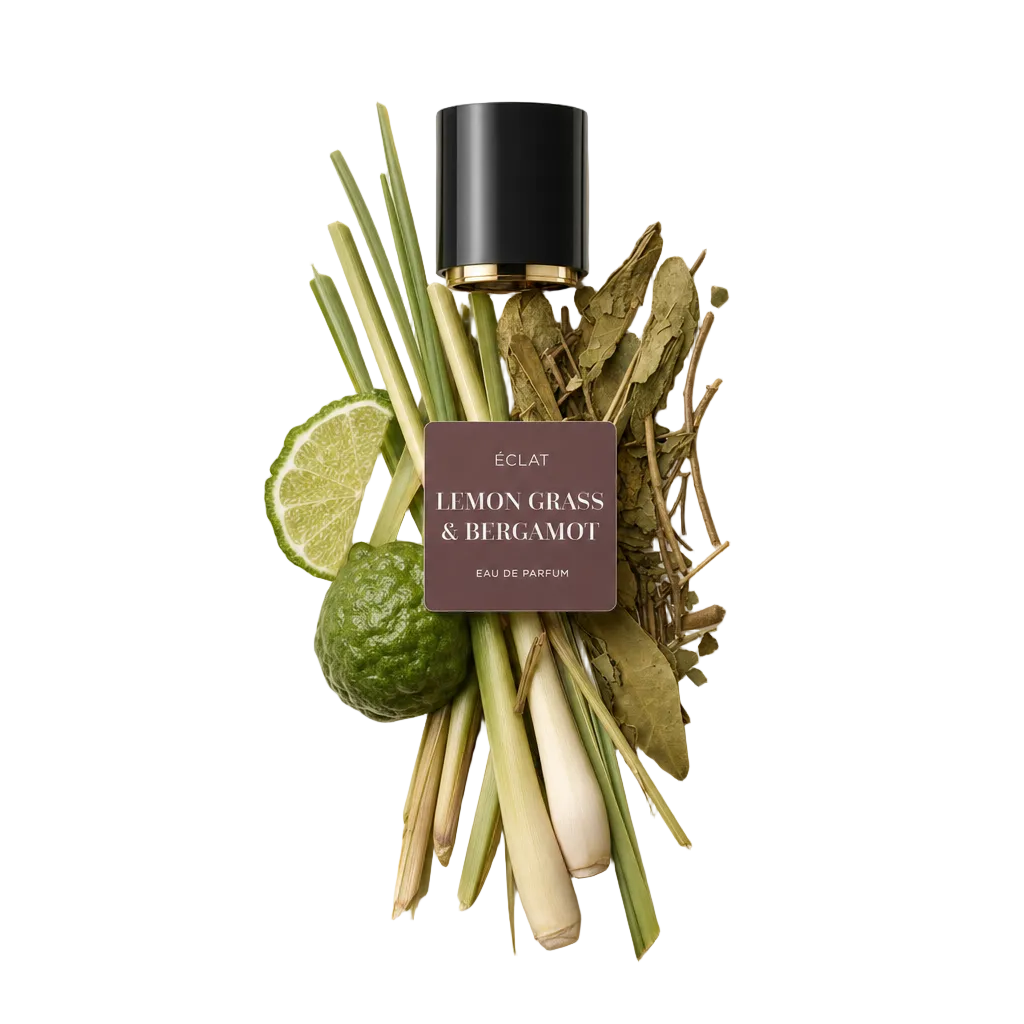 Un arrangement de tiges de citronnelle, de feuilles de kaffir lime, de tranches de lime et de bergamote entière, à côté d'un capuchon noir avec étiquette ÉCLAT Lemon Grass & Bergamot.