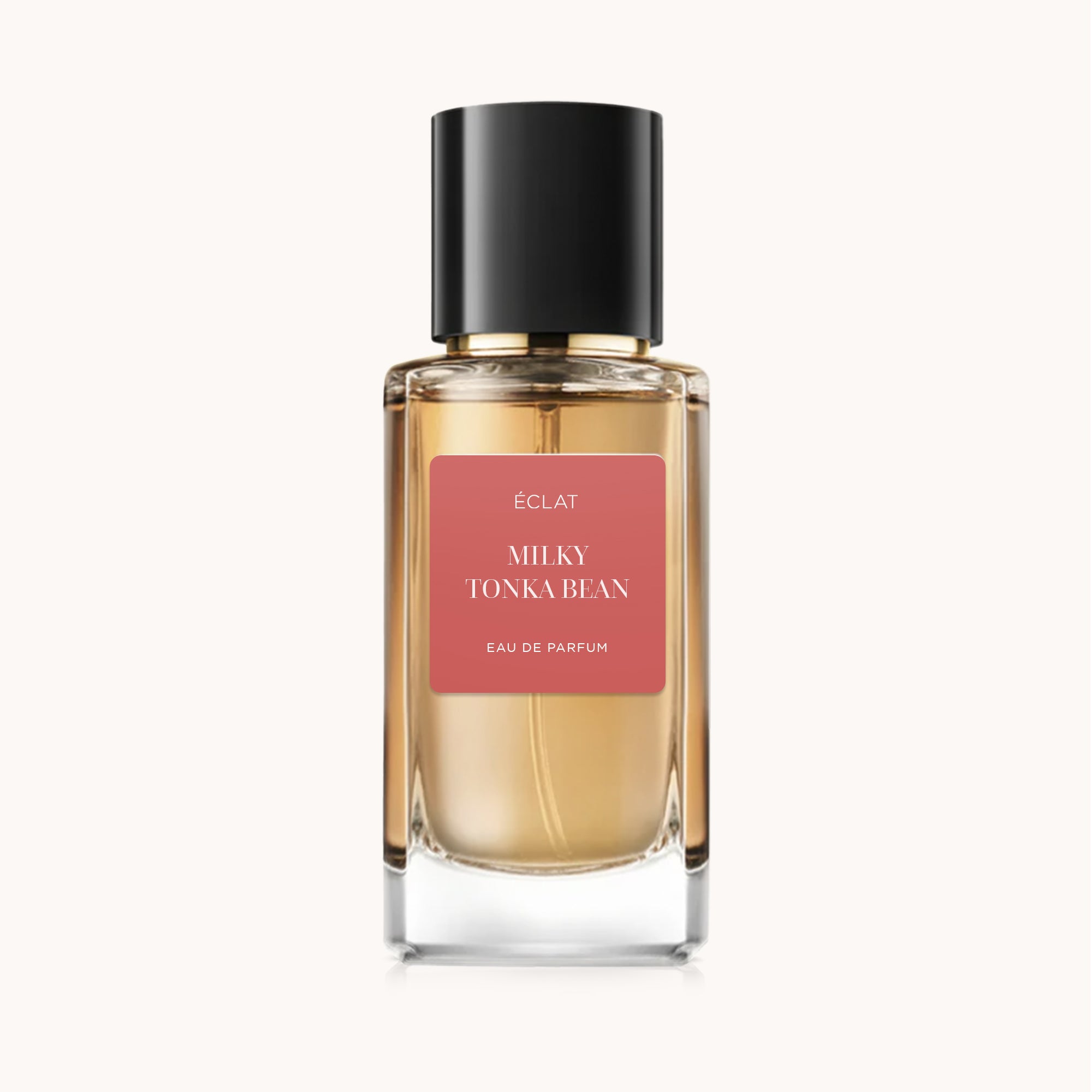 Faceted glass flacon with black cap featuring ÉCLAT Milky Tonka Bean label on a soft background.