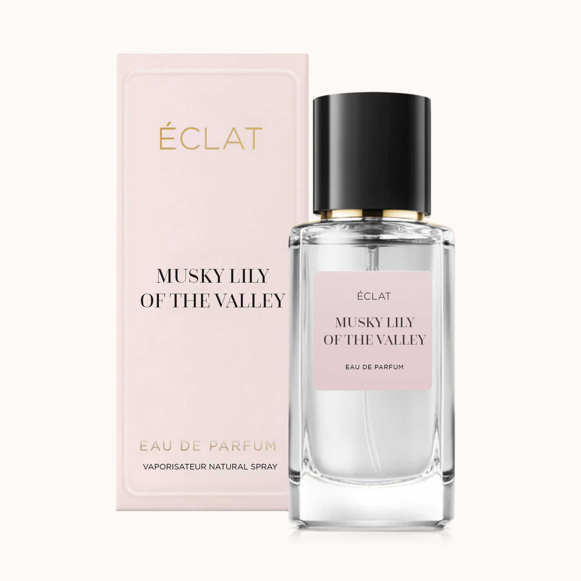 A faceted glass bottle of ÉCLAT Musky Lily of the Valley with a black cap, accompanied by a pale pink box.