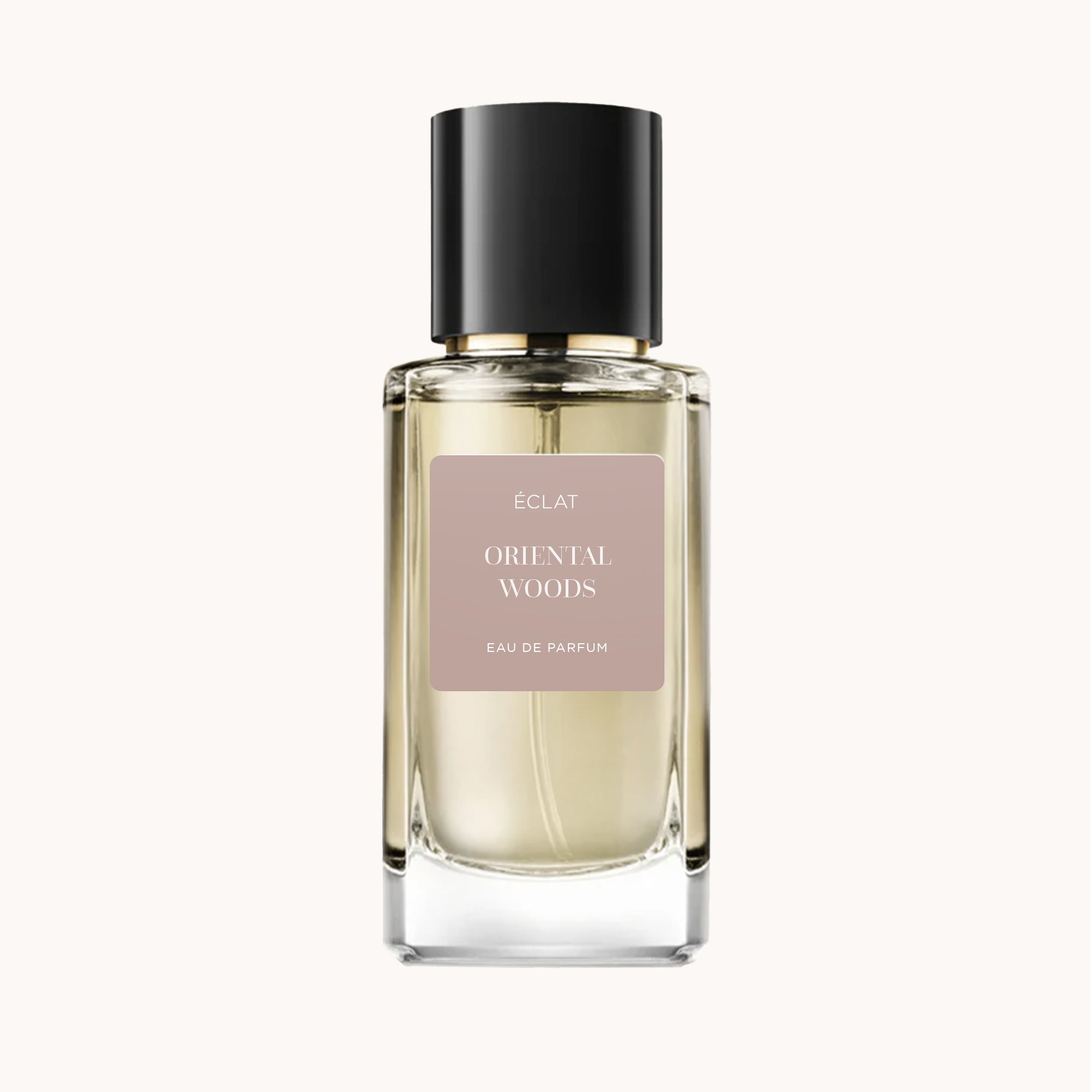 Parfum ÉCLAT Oriental Woods dans un flacon en verre facetté clair avec un bouchon noir brillant et une étiquette beige douce.
