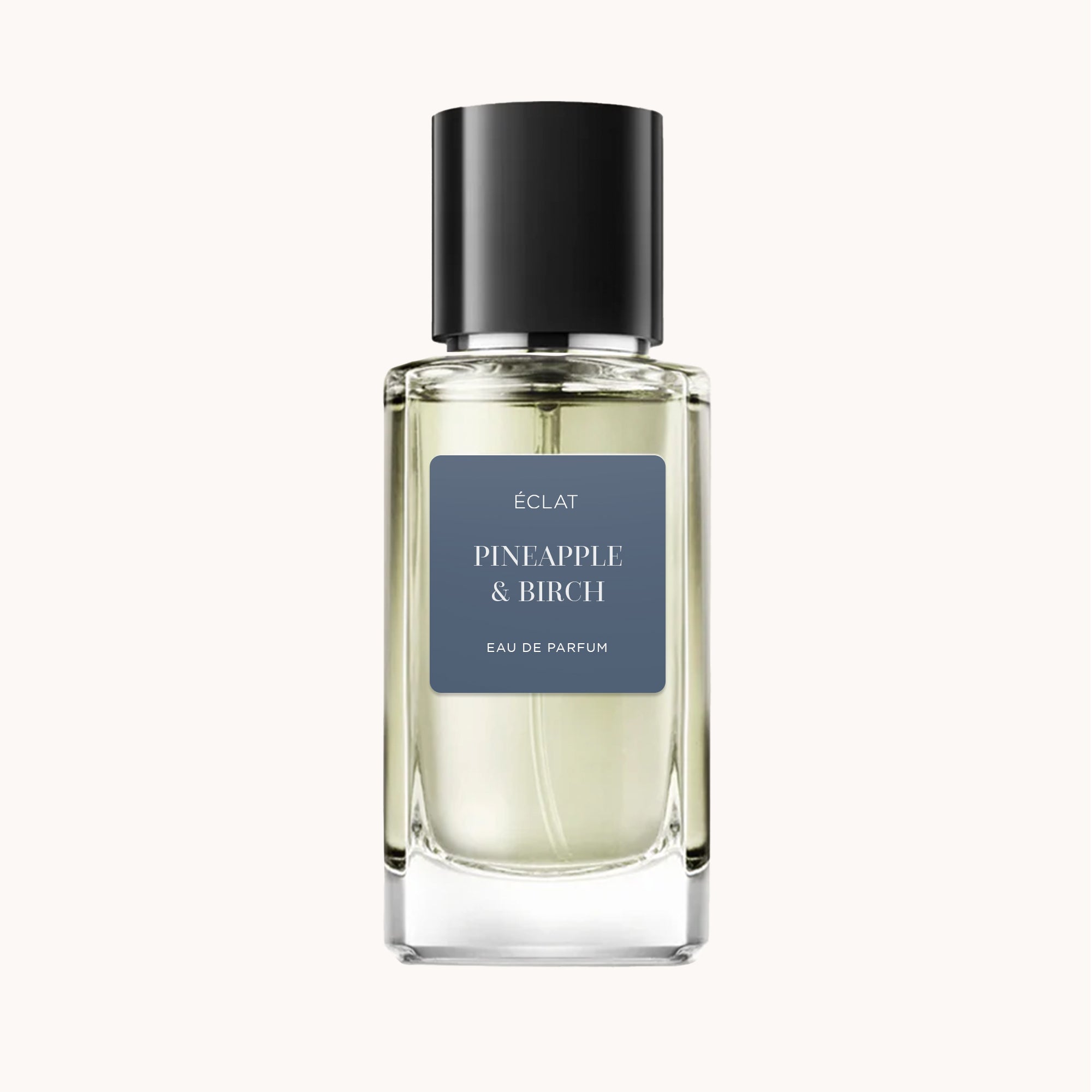 The ÉCLAT Pineapple & Birch fragrance in a clear glass bottle with a black cap and a dark label.