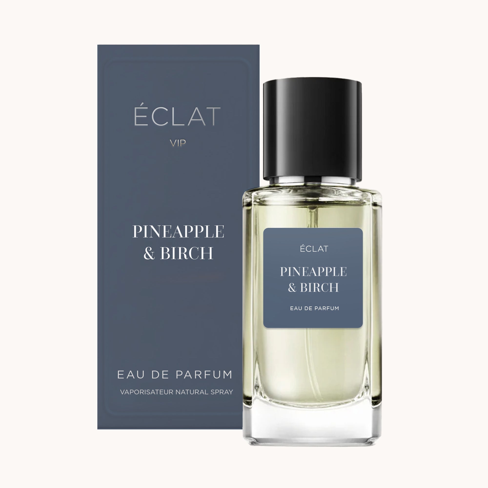 ÉCLAT Pineapple & Birch perfume in a clear glass bottle with a black cap, alongside a matching dark blue box.