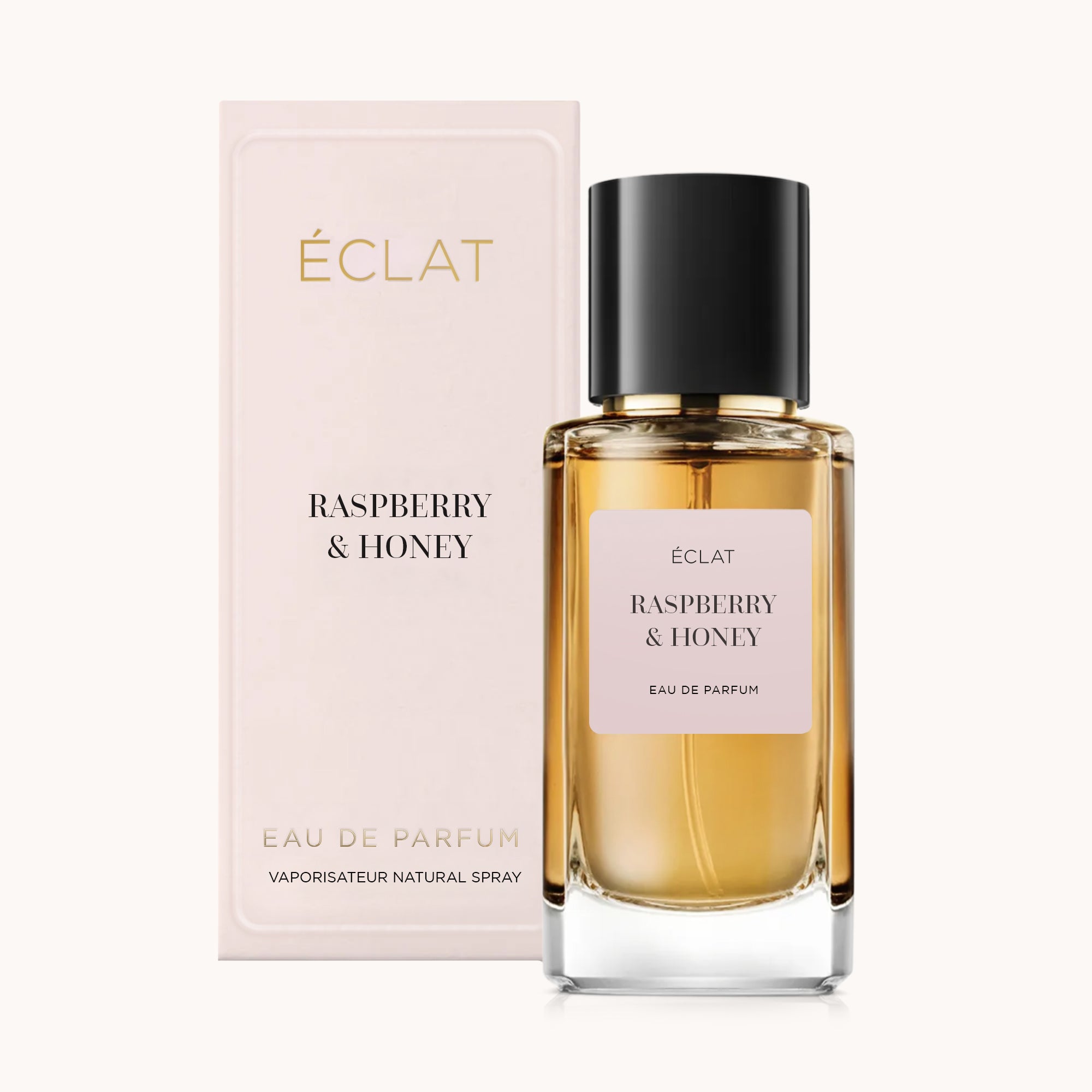 Een gefacetteerde glazen fles van ÉCLAT Raspberry & Honey met een zwarte dop wordt getoond naast een bijpassende elegante doos.