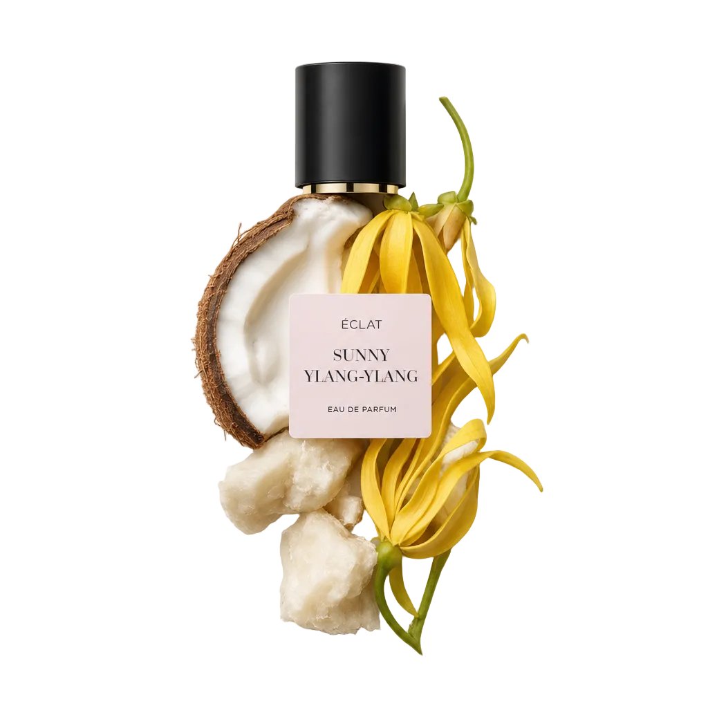 Ett arrangemang av färska ylang-ylang-blommor, halverad kokosnöt och bitar av sheasmör, med en svart kork märkt ÉCLAT Sunny Ylang-Ylang.