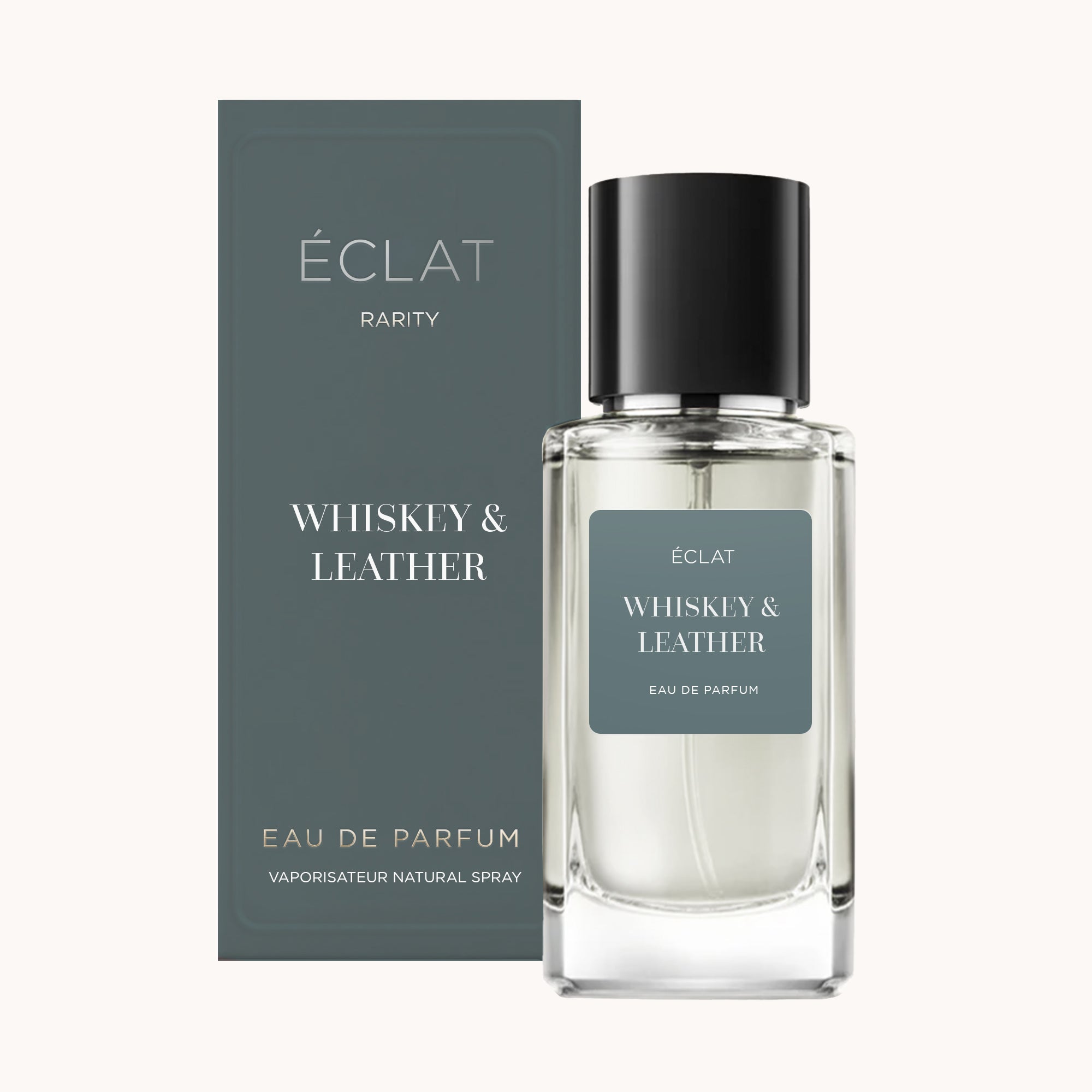ÉCLAT Whiskey & Leather fragrance in a clear glass bottle with a black cap, accompanied by its matching elegant box in muted blue.