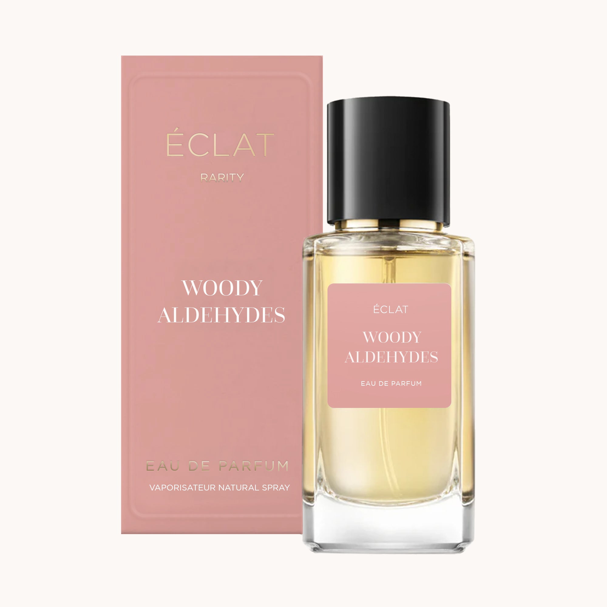 ÉCLAT Woody Aldehydes i en fasetterad glasflaska med svart lock, åtföljd av en rosa ask.