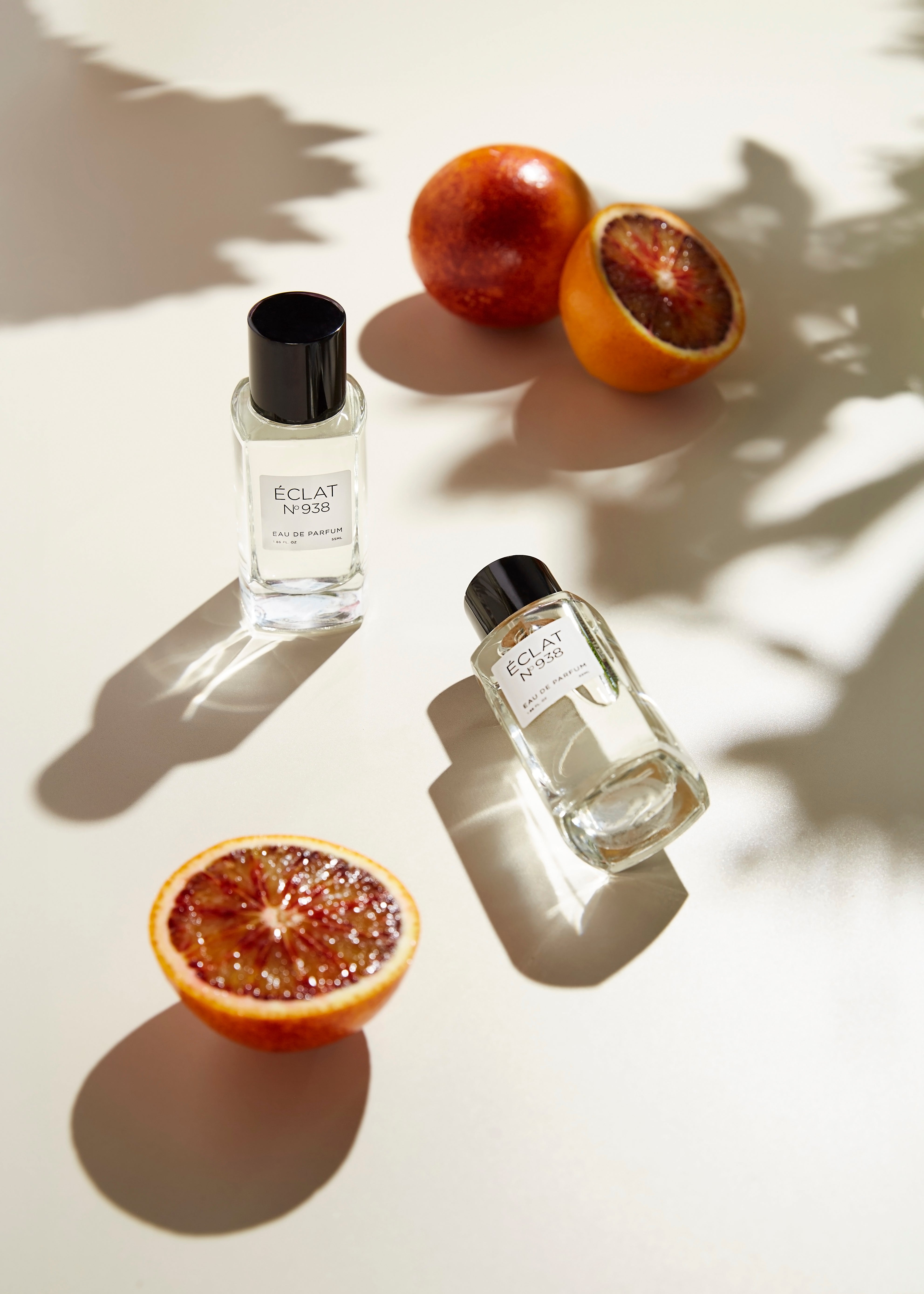 ÉCLAT 938 unisex summer fragrance bottle styled with fresh blood oranges and palm shadows – vibrant citrus perfume for all genders in the ÉCLAT Unisex Collection.