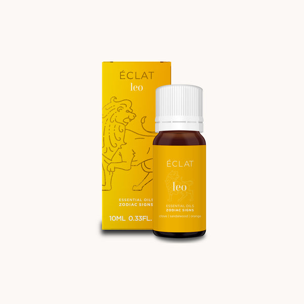 Frasco de vidrio ámbar de ÉCLAT Natural Oil Blend - Zodiac Sign Leo con tapa blanca, junto a caja amarilla con ilustración de león.