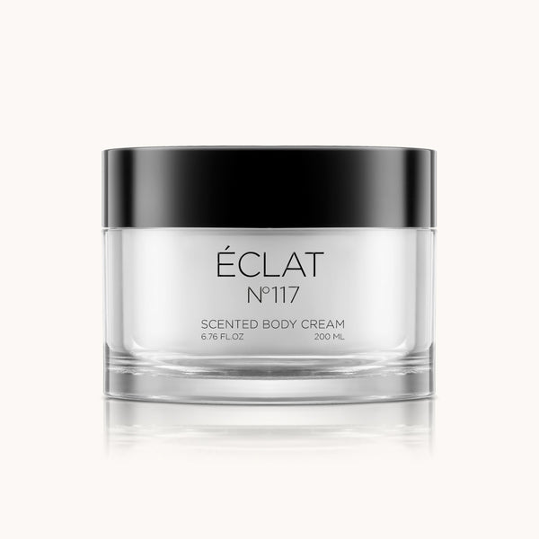 Un frasco transparente y lujoso con tapa negra que muestra la Crema Corporal ÉCLAT 117.