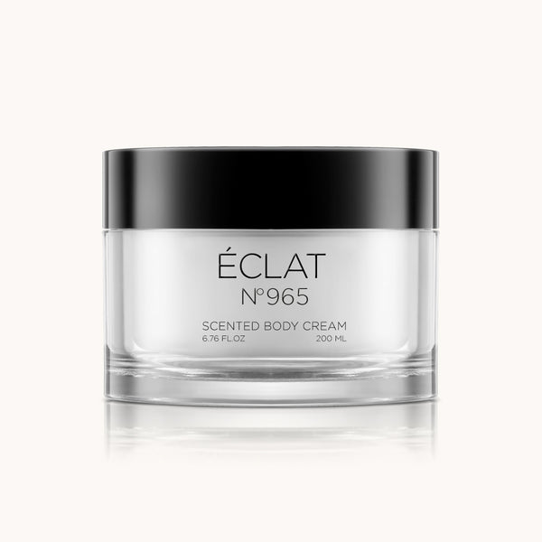 Crema corporal ÉCLAT 965 en tarro transparente con tapa negra, elegantemente presentada.