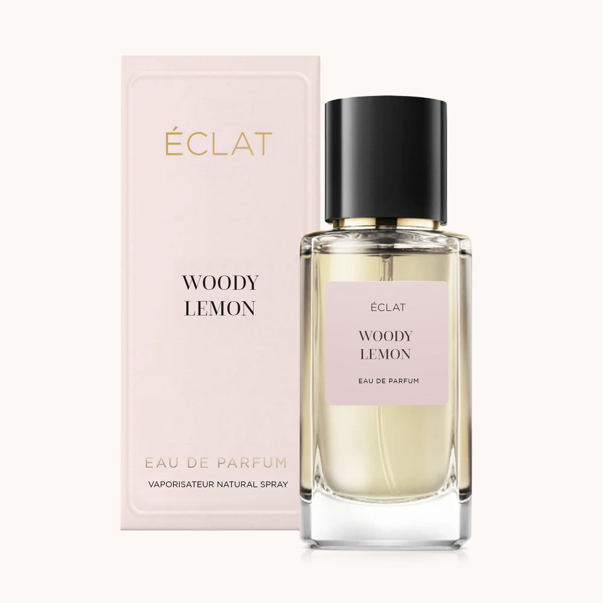 En facetterad glasflaska av ÉCLAT Woody Lemon med svart lock, bredvid en blekrosa låda med samma namn.