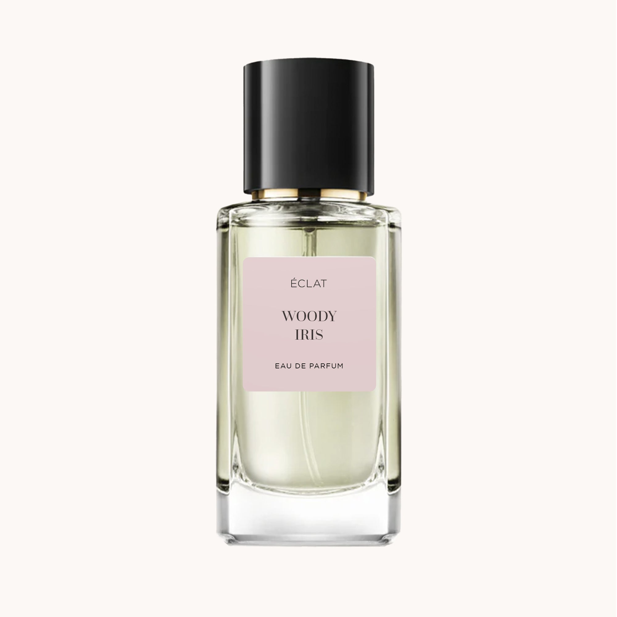 Flacon en verre facetté d'ÉCLAT Woody Iris avec un bouchon noir élégant et une étiquette rose douce.