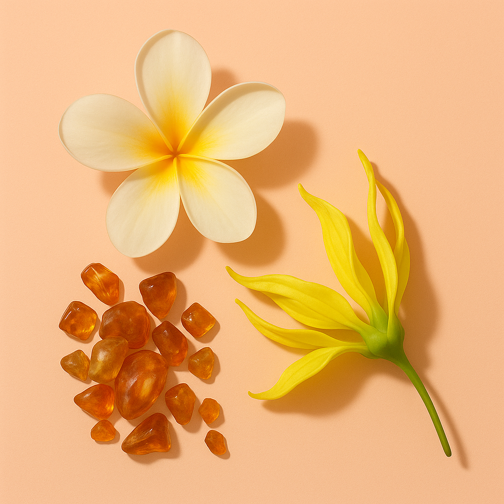 A composition of a frangipani flower, yellow ylang-ylang blossom, and amber stones on a light peach background.