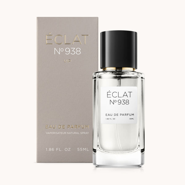 Un frasco de vidrio facetado de ÉCLAT VIP Ambery Saffron con tapa negra está junto a una elegante caja beige mate.
