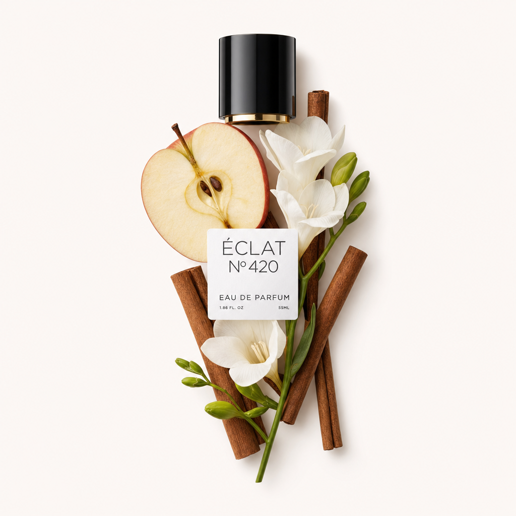 Une nature morte soigneusement arrangée de tranches de pomme, bâtons de cannelle et fleurs blanches autour d’un bouchon noir avec l'étiquette ÉCLAT Apple & Cinnamon.