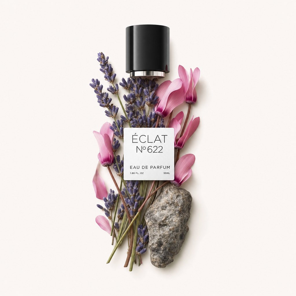 An arrangement of lavender sprigs and pink cyclamen flowers alongside a textured stone, topped by ÉCLAT's original black cap with a label.