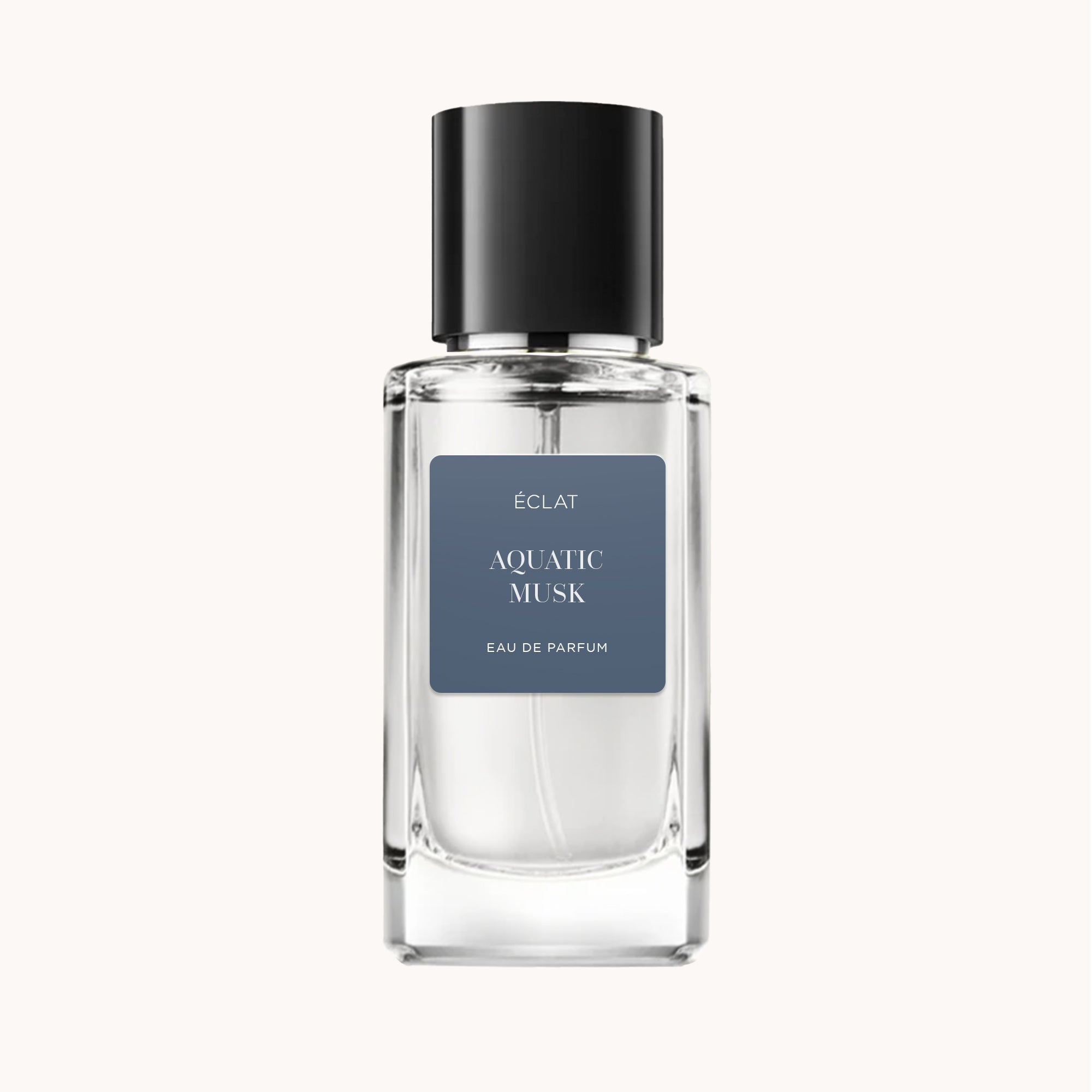 Frasco de vidro facetado com tampa preta e etiqueta azul exibindo ÉCLAT Aquatic Musk.