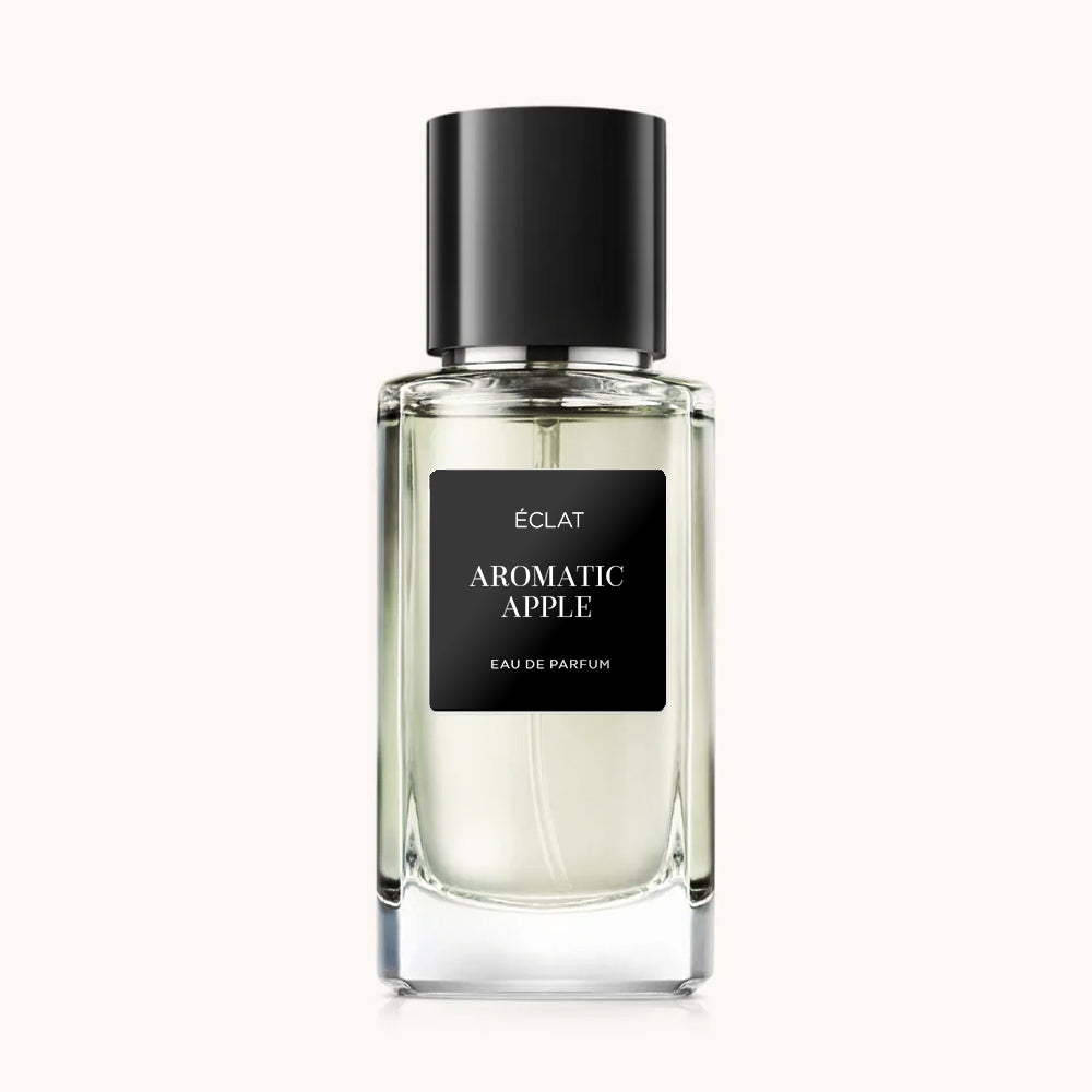 Clear glass flacon with a black matte label and a black cap, showcasing ÉCLAT Aromatic Apple fragrance.