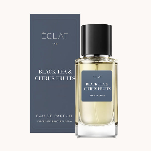 Frasco de perfume ÉCLAT VIP Black Tea & Citrus Fruits con etiqueta azul oscuro y caja a juego.