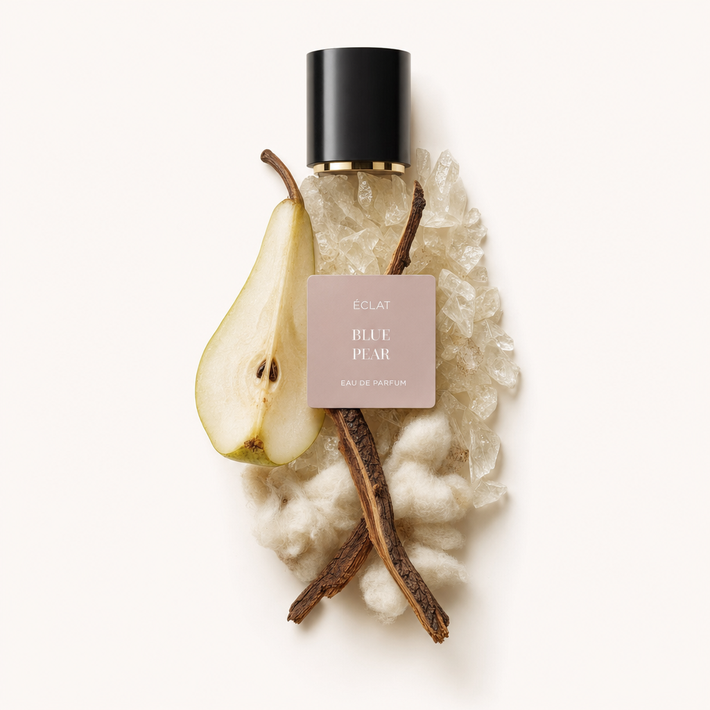 An elegant arrangement of vanilla beans, a sliced pear, white cotton, and clear crystals surrounds the ÉCLAT Blue Pear VIP cap with a black and gold finish.