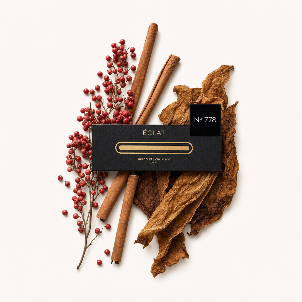 A sophisticated arrangement of red pepper berries, cinnamon sticks, and tobacco leaves surrounds a black cap with ÉCLAT No 778 label.