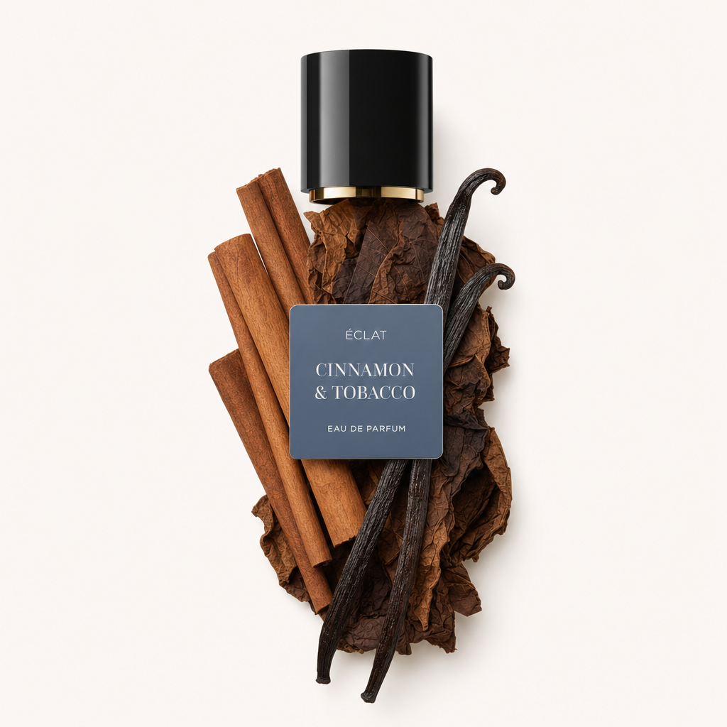 Une composition de bâtons de cannelle, de feuilles de tabac et de gousses de vanille entoure un capuchon noir avec une étiquette portant le nom ÉCLAT Cinnamon & Tobacco.