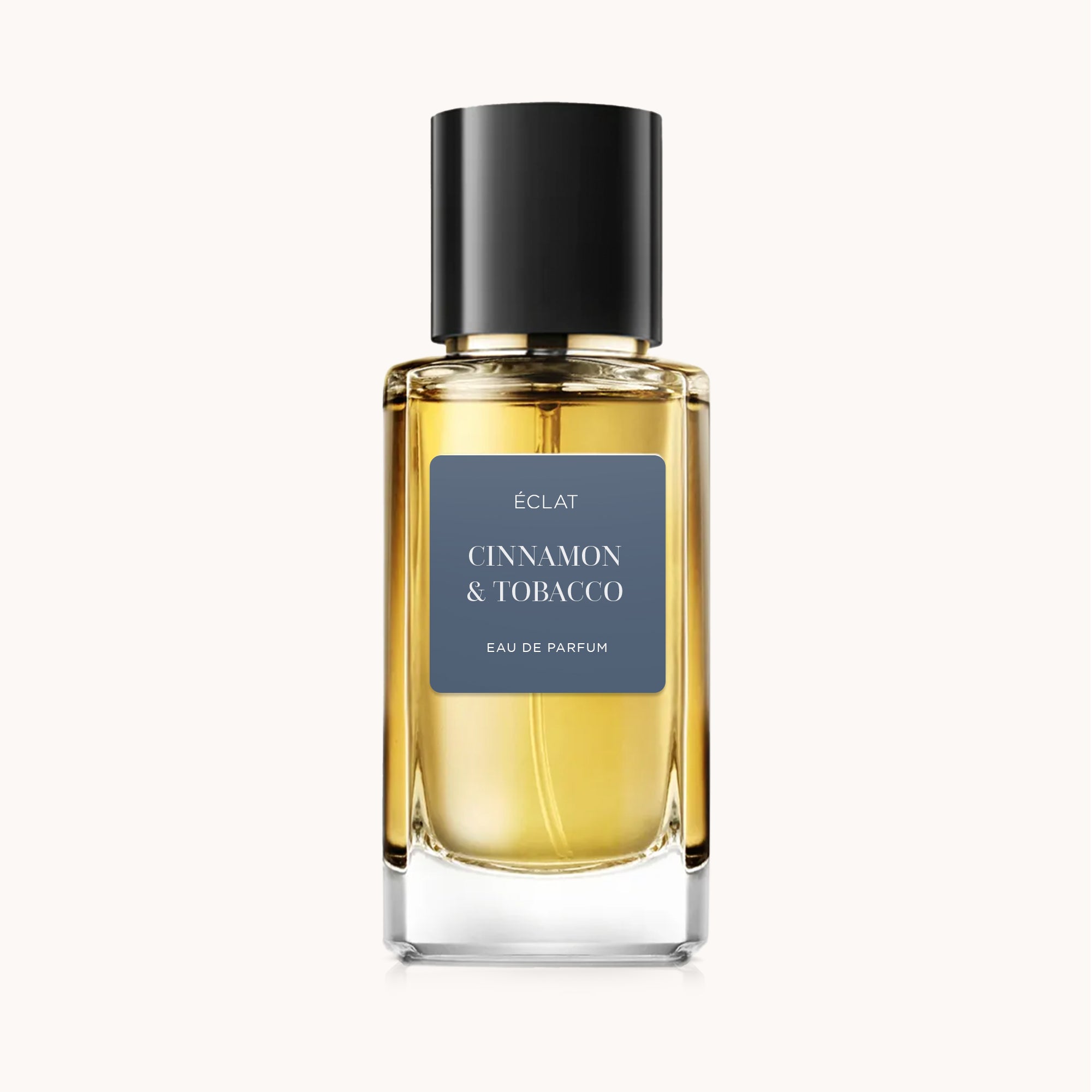 Fragrância ÉCLAT Cinnamon & Tobacco em garrafa de vidro facetado com tampa preta e rótulo mate.