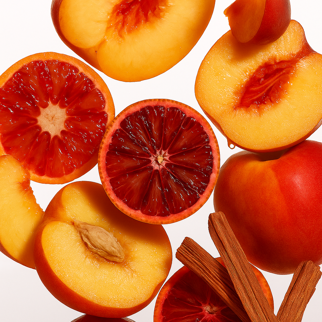 Fatias de pêssego fresco e laranja sanguínea com paus de canela sobre fundo branco, evocando o aroma de ÉCLAT VIP - Cognac & Peach.