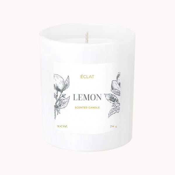 Vela Perfumada de Cera de Soya ÉCLAT Lemon en un recipiente de vidrio blanco con etiqueta ilustrada.