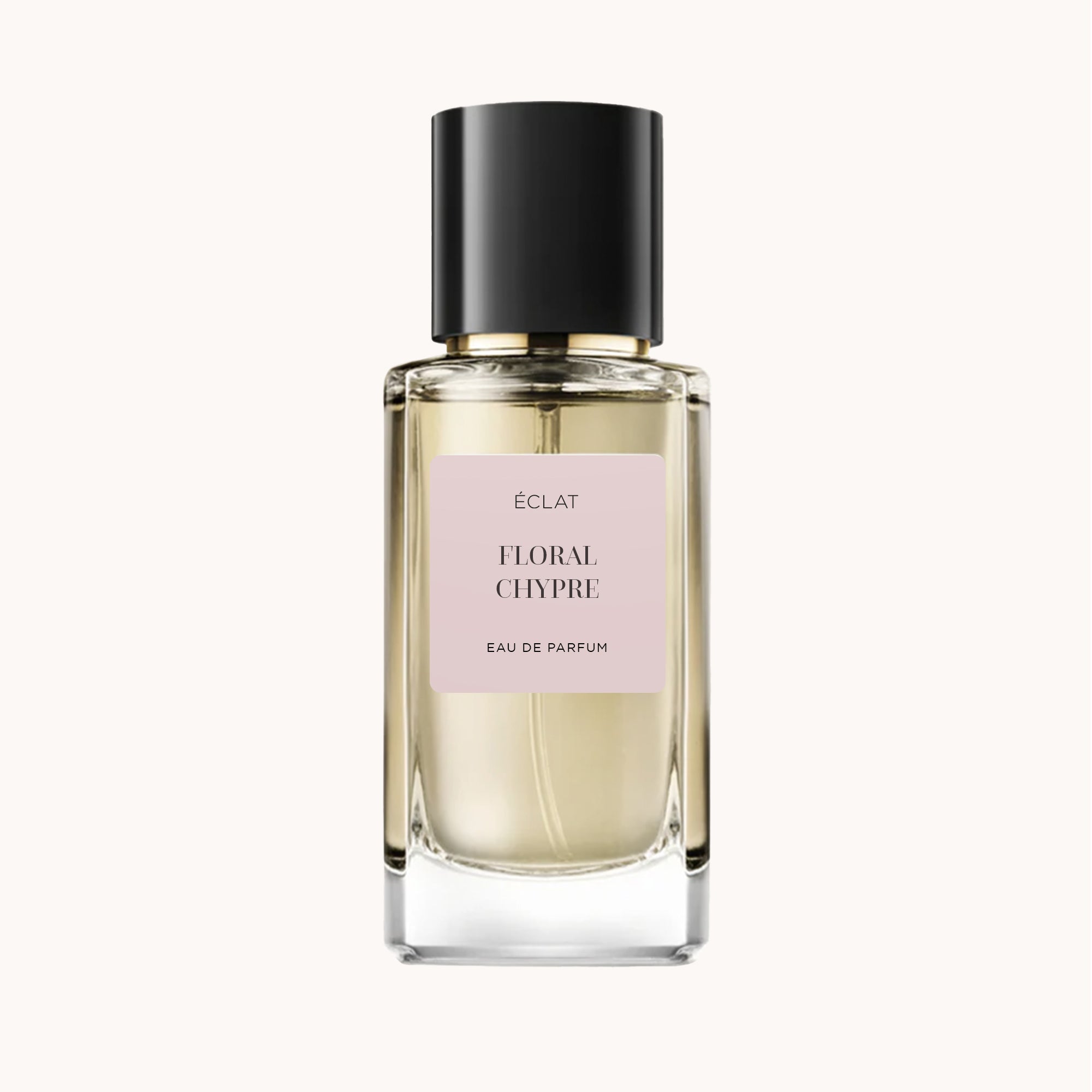 Le flacon de parfum ÉCLAT Floral Chypre se distingue par un design en verre transparent avec une étiquette rose pâle et un bouchon noir élégant.