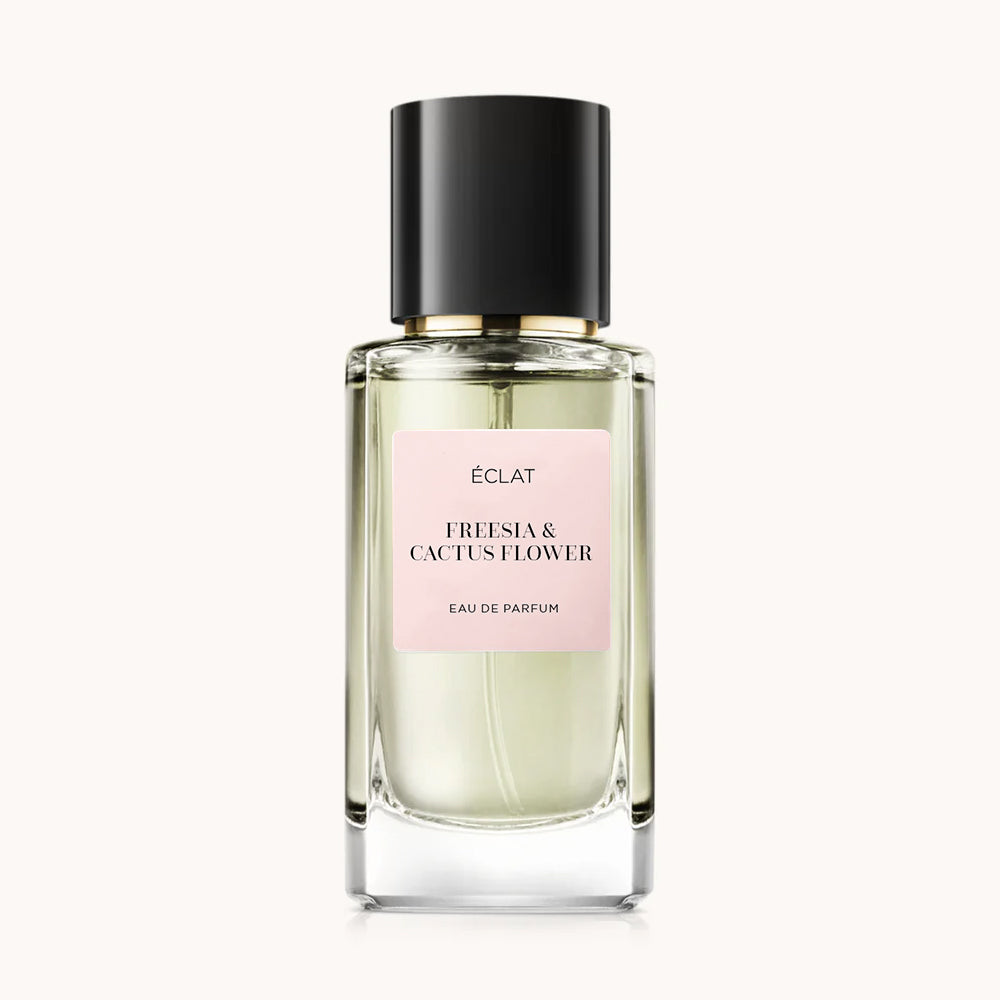 Faceted glass bottle with a black cap and a pale pink label displaying ÉCLAT Freesia & Cactus Flower.