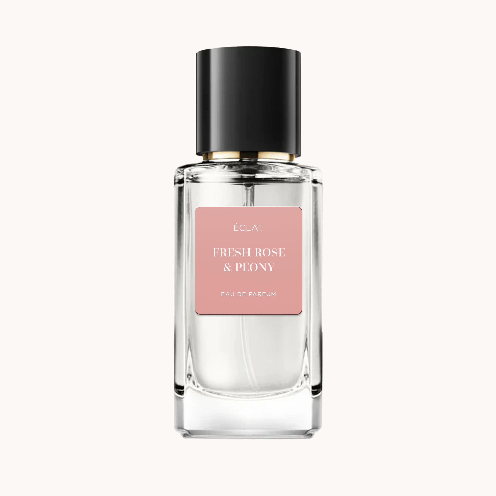 Un flacon en verre facetté de ÉCLAT Fresh Rose & Peony avec une étiquette rose mat et un bouchon noir élégant.