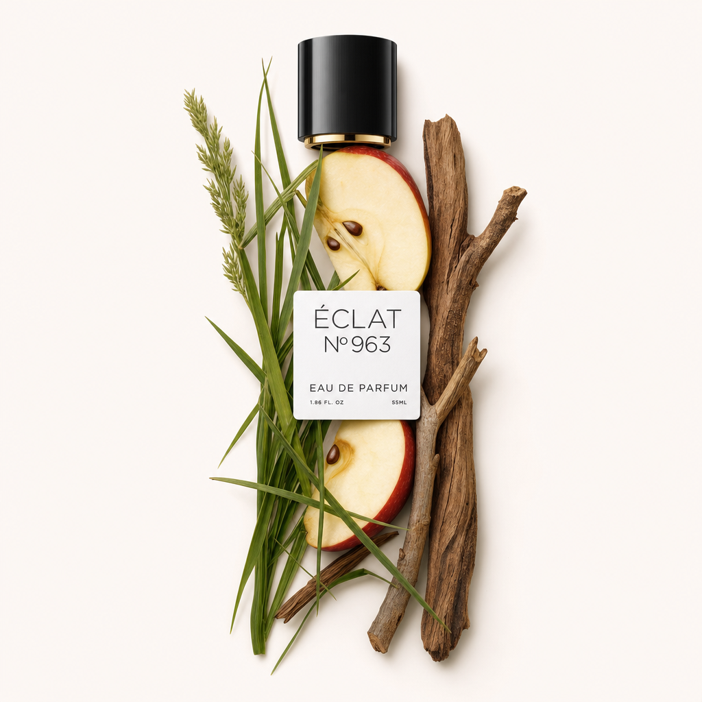 Un arrangement de tranches de pomme, d'herbe fraîche et de bâtons de bois entoure un bouchon noir avec une étiquette pour ÉCLAT Fruity Grass.