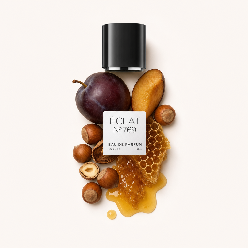 An arrangement of a ripe plum, hazelnuts, honeycomb, and honey surrounds a black cap with ÉCLAT label.