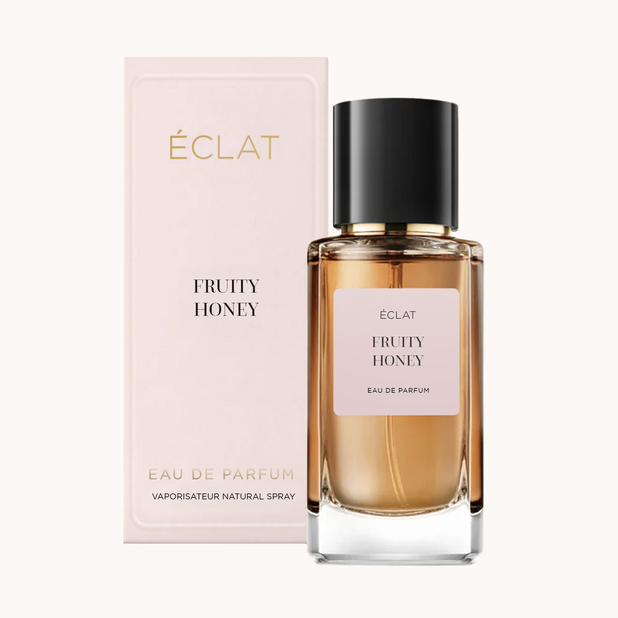 A faceted glass bottle of ÉCLAT Fruity Honey with a black cap, positioned in front of a soft pink packaging box.
