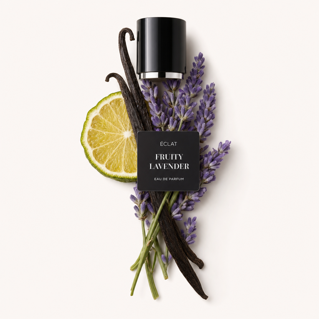 Un arrangement de gousses de vanille, de brins de lavande et d'une tranche de citron vert entoure un bouchon noir avec une étiquette ÉCLAT Fruity Lavender.