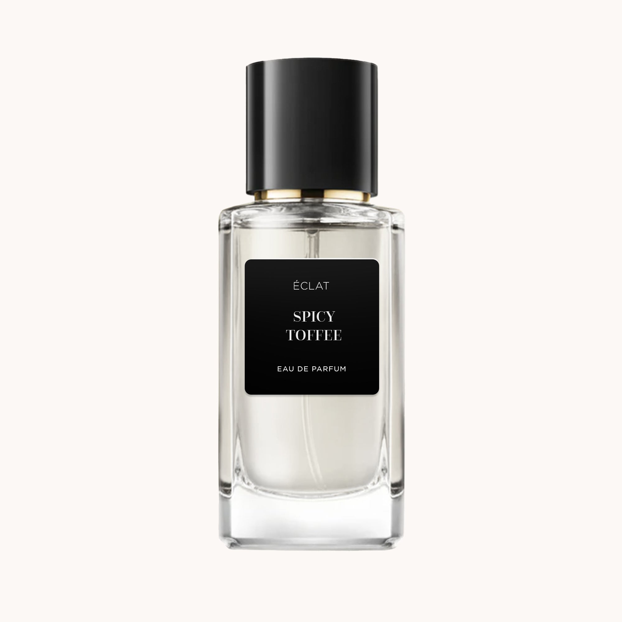 O perfume ÉCLAT Spicy Toffee apresenta um frasco de vidro facetado transparente com rótulo preto mate e tampa preta elegante.