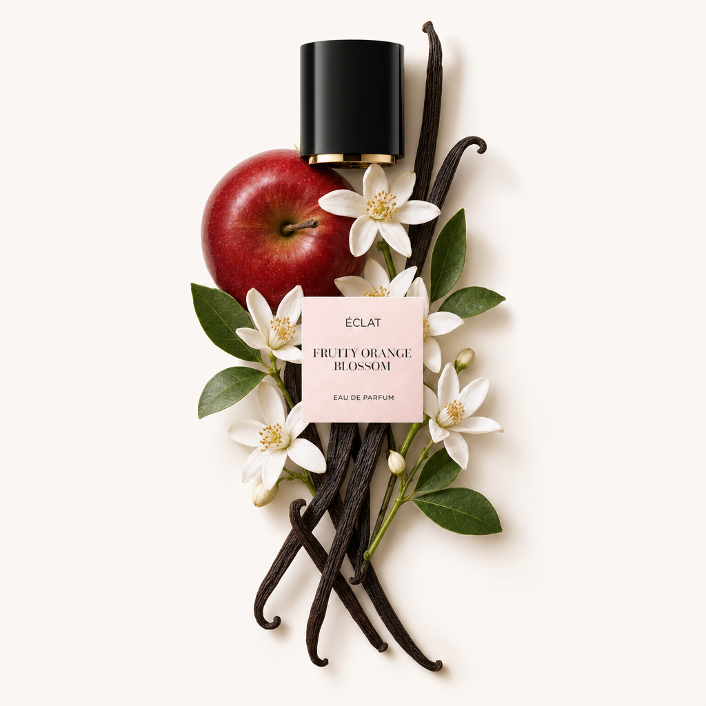 Un arrangement artistique de pomme rouge, fleurs d'oranger blanches et gousses de vanille entoure le capuchon noir avec étiquette ÉCLAT Fruity Orange Blossom.