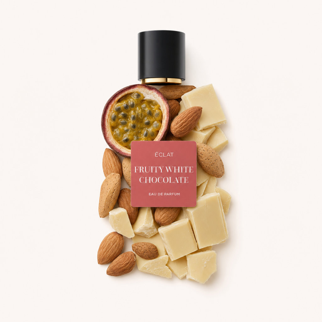 Un arrangement artistique d'un demi-fruit de la passion, d'amandes entières et de morceaux de chocolat blanc crémeux sous un bouchon noir avec une étiquette pour ÉCLAT Fruity White Chocolate.