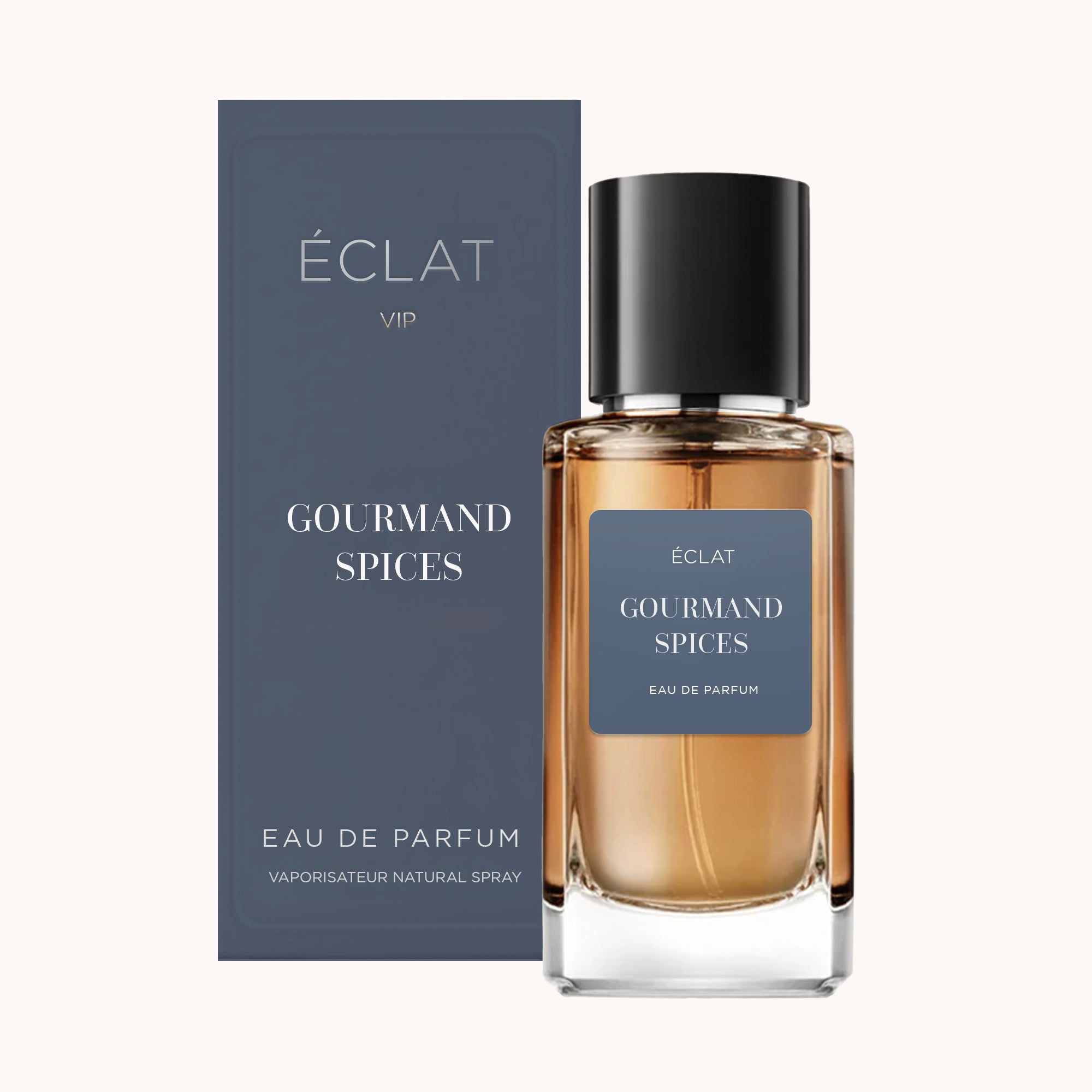 Un flacon en verre facetté avec un liquide sombre et un bouchon noir mat est accompagné d'une boîte bleue, étiquetée ÉCLAT Gourmand Spices.