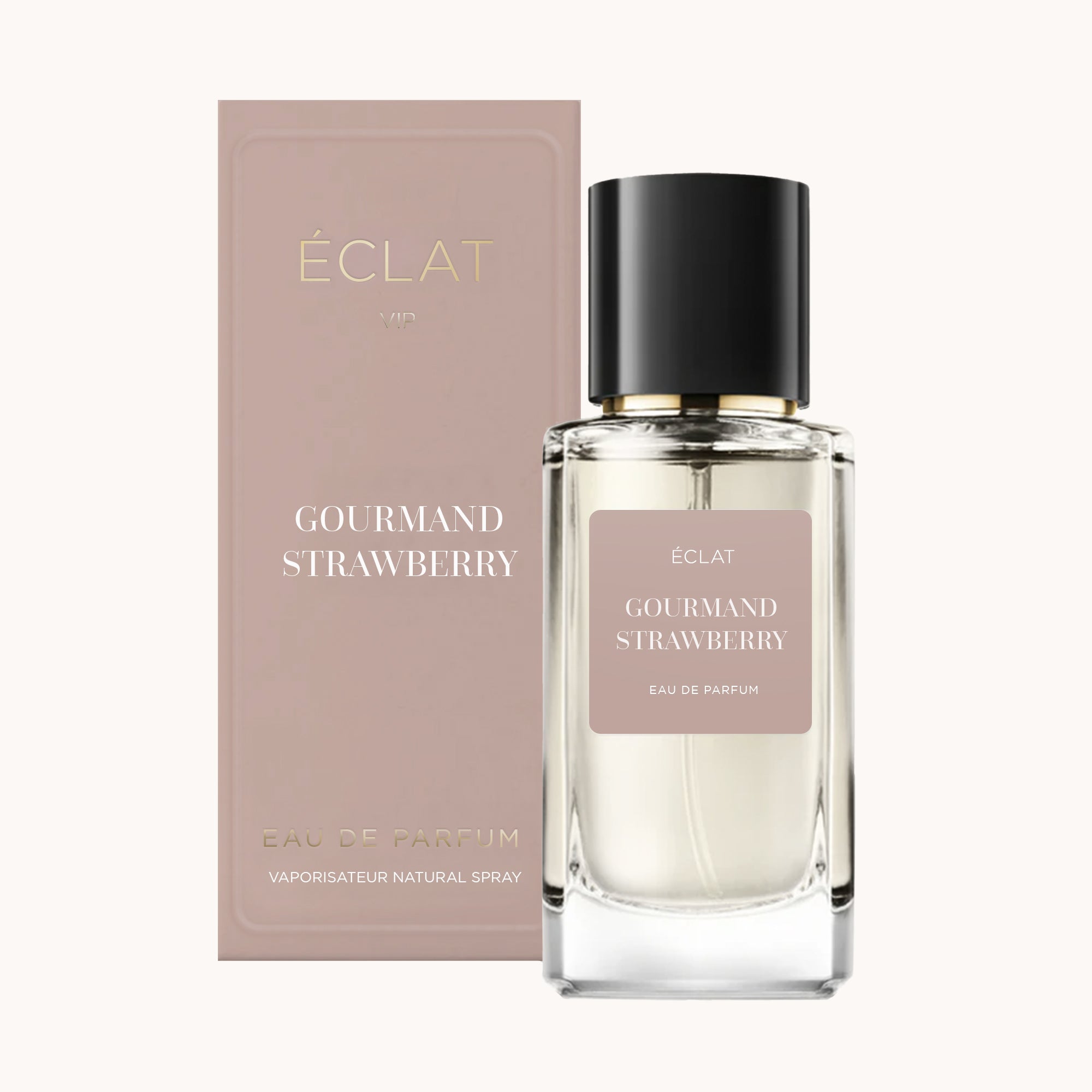 Faceted glass flacon of ÉCLAT Gourmand Strawberry with a black cap beside a matching pink packaging.