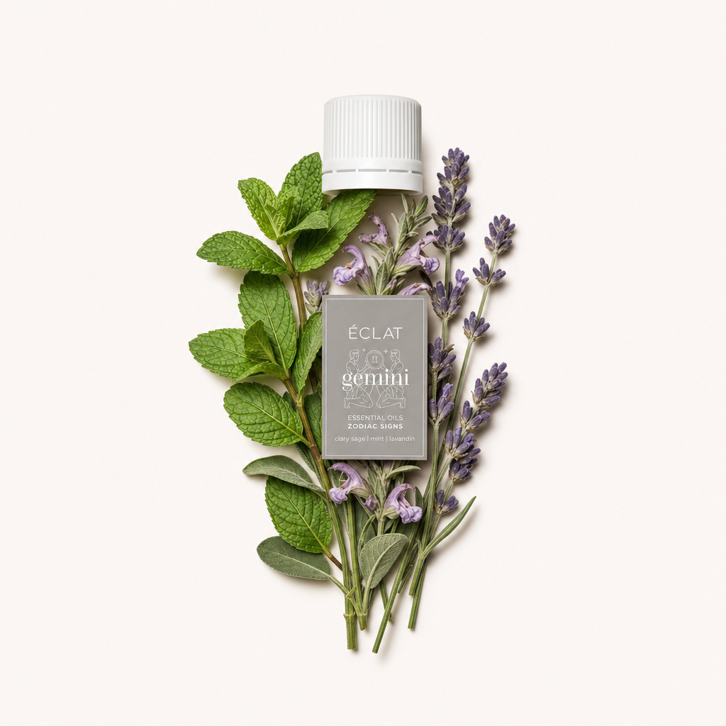 Friss menta- és levendulalevelek elrendezése egy címkével ellátott fehér kupakot körülvéve mutatja be az ÉCLAT Natural Oil Blend - Zodiac Sign Gemini esszenciáját.