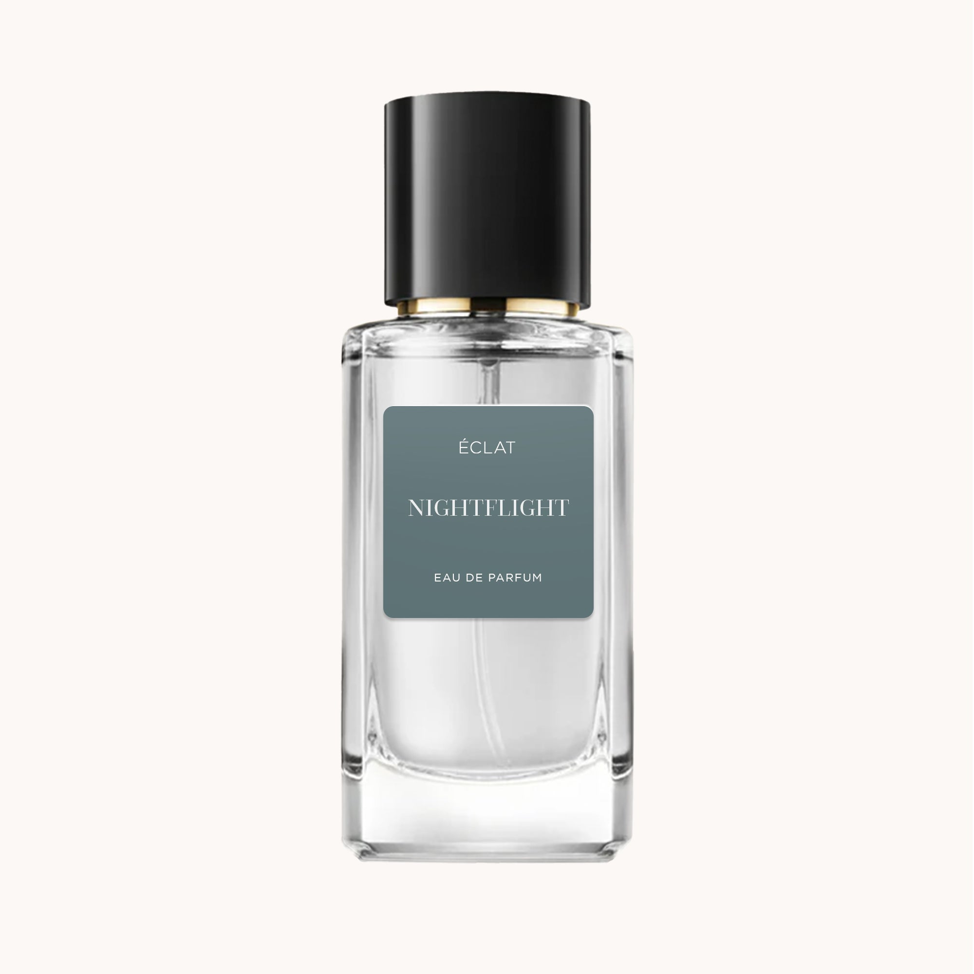 A faceted glass bottle of ÉCLAT Nightflight with a sleek black cap and a matte gray label.