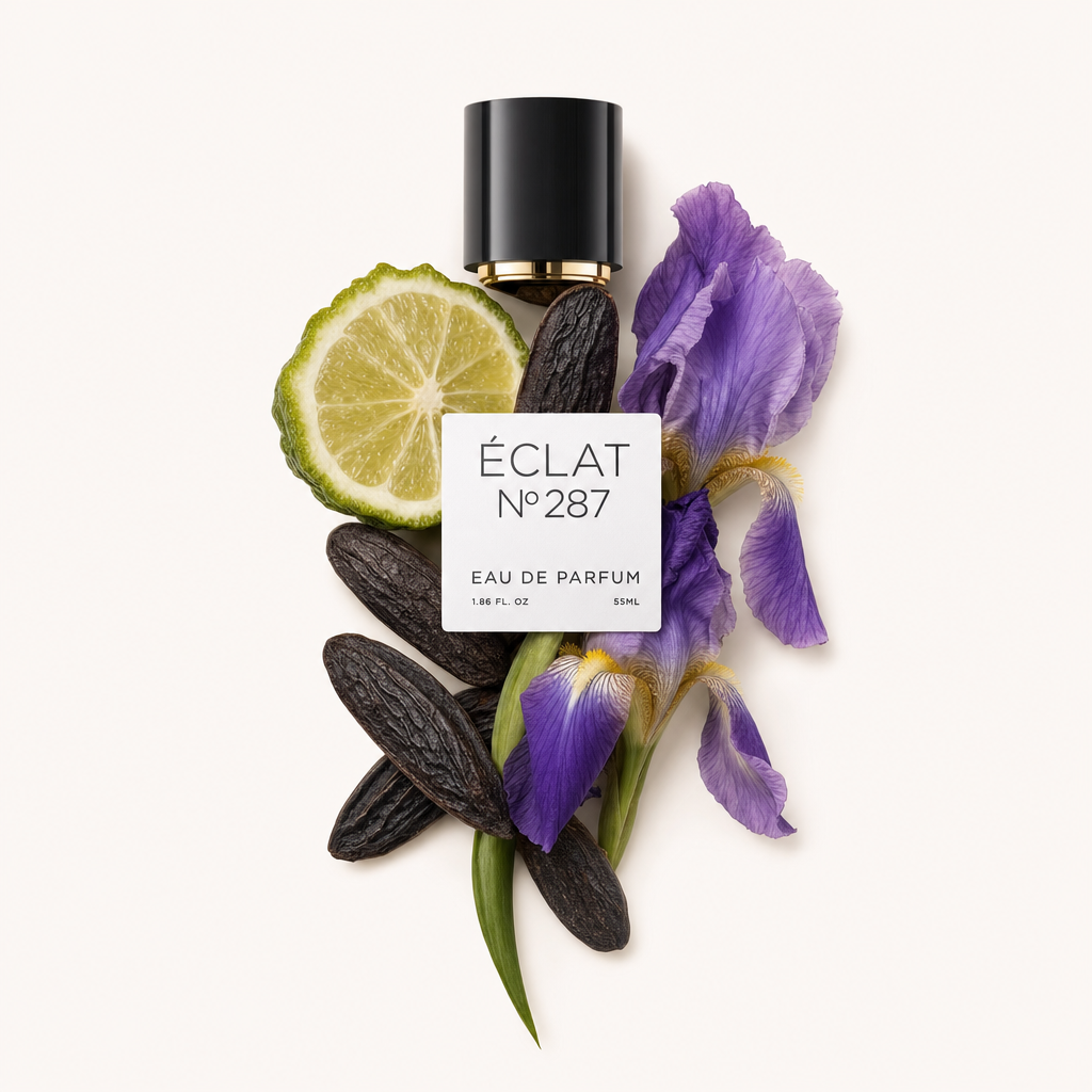 A composition of perfume ingredients for ÉCLAT Oriental Iris featuring a slice of lime, tonka beans, and purple iris flowers, with a black cap and label.