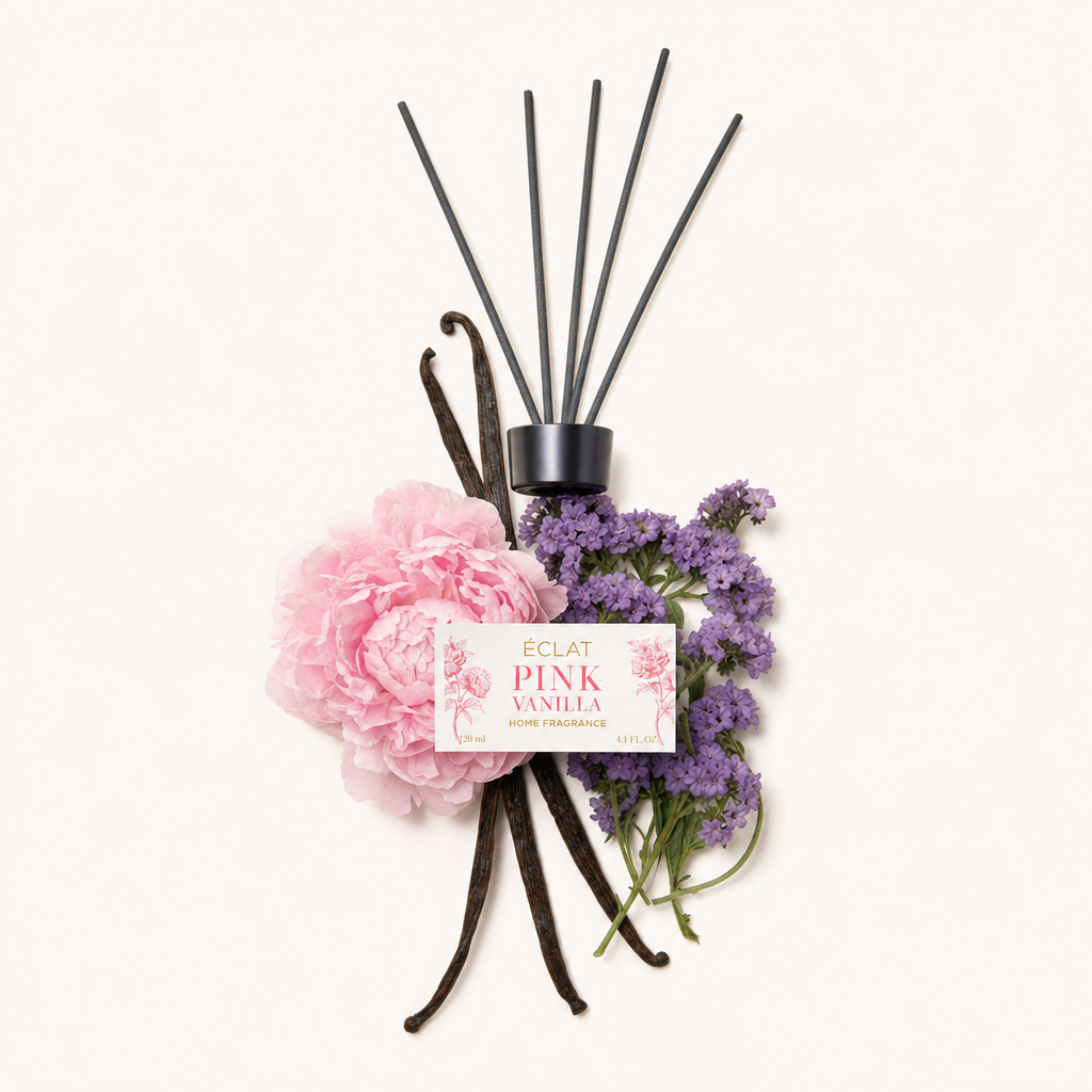 Ett arrangemang av rosa pioner, vaniljstänger och lavendelkvistar, som omger en svart lock med ÉCLAT Pink Vanilla-etikett.