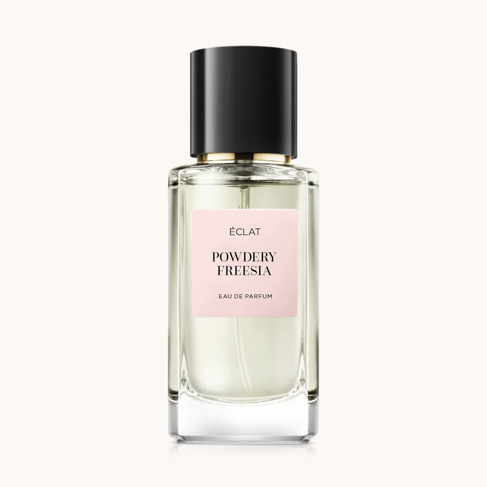 Flacon en verre facetté d'ÉCLAT Powdery Freesia avec un bouchon noir et une étiquette rose pâle.