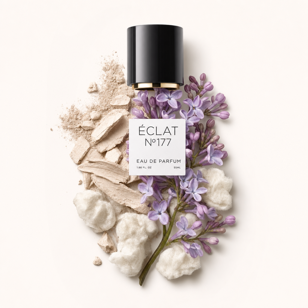 Un arrangement de fleurs de lilas aux délicates teintes violettes, entouré de coton blanc doux et de fragments de poudre beige. En haut se trouve un capuchon noir avec un bord doré et une étiquette ÉCLAT.